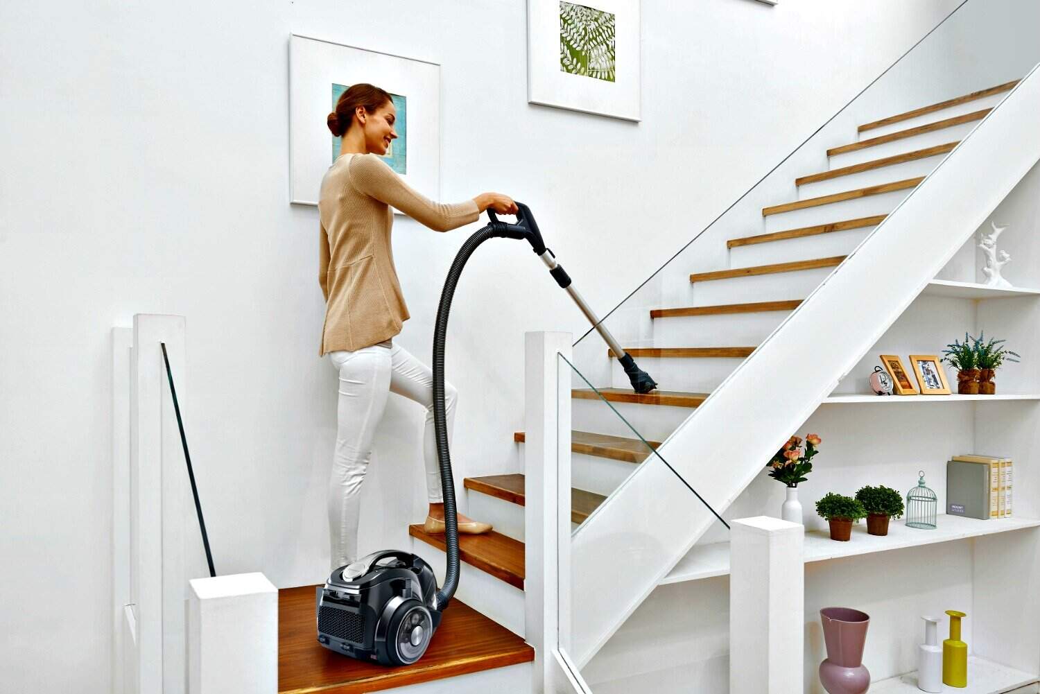 Cordless vacuum cleaner in use on staircase.