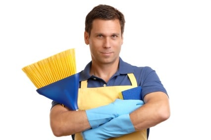 Man holding cleaning tools with a confident smile, ready to organize household chores.