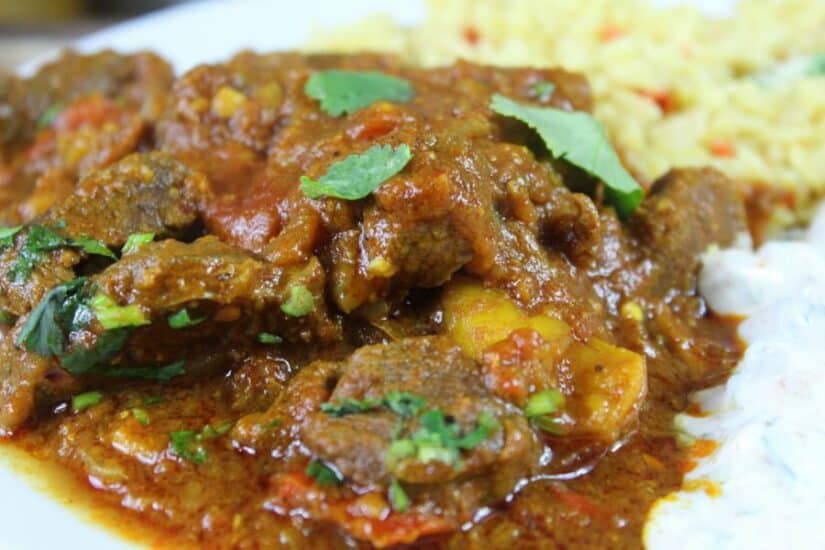 Delicious beef curry served with fluffy rice, garnished with fresh herbs, perfect for family dinners.