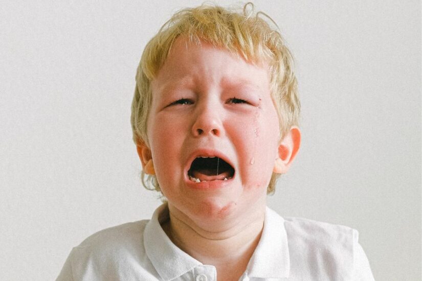 Young boy crying, upset child at home, emotional distress.