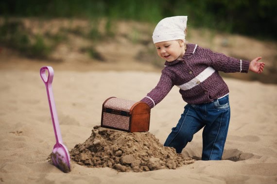Child digging for treasure on the beach.