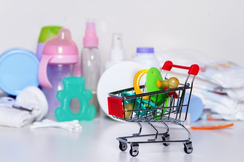 Baby toy shopping cart filled with teething toys and baby care items.