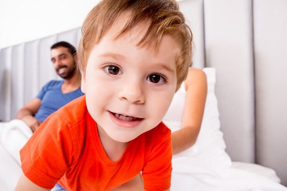 Toddler in bed with parent, promoting healthy sleep habits and boundaries.