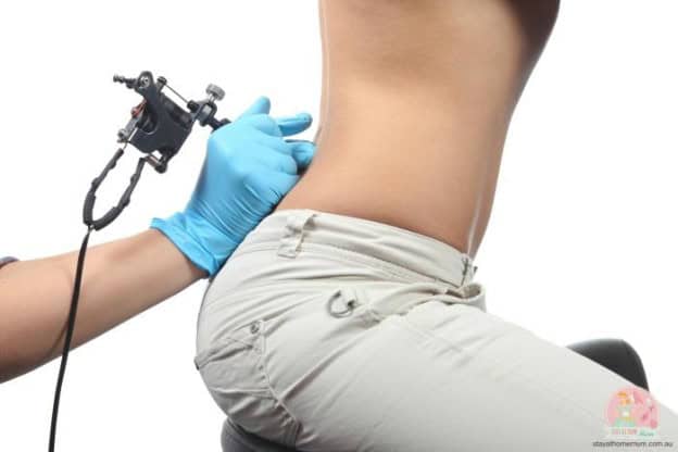 Woman getting a tattoo on her abdomen while breastfeeding, safe tattoo practices.