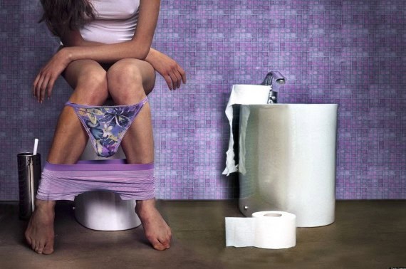 Humorous bathroom scene featuring a woman sitting on a toilet with her underwear down.