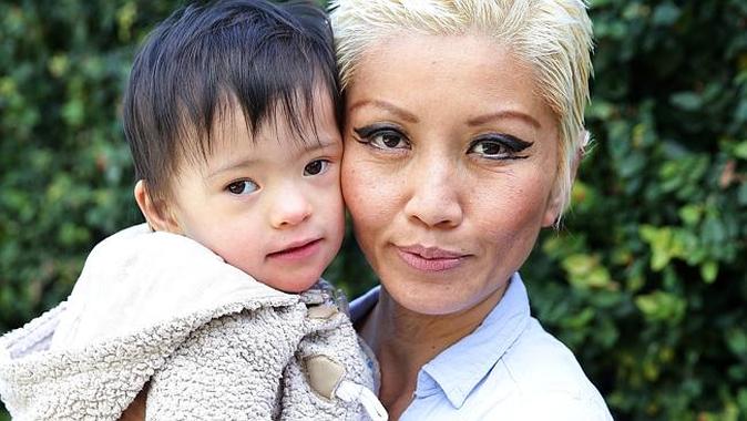 Mother and young child close-up, outdoor setting, emotional moment.