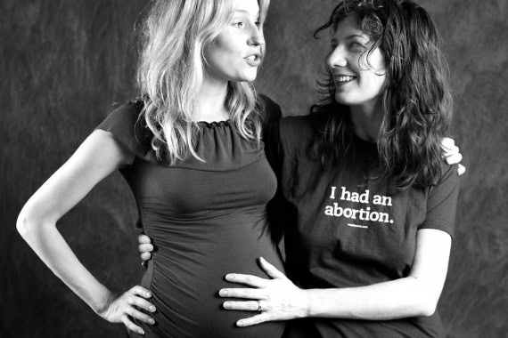 Two women, one pregnant, sharing a moment of support and empowerment.