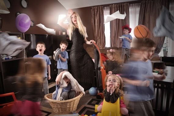 Cluttered living room with kids and laundry chaos, illustrating a hectic day at home.