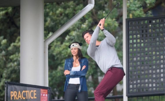 Man practicing golf swing outdoors.