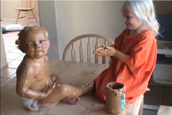 Children enjoying peanut butter together in a kitchen setting.