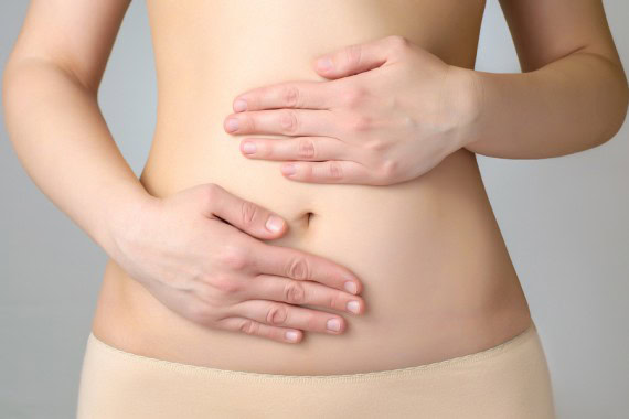 Woman holding her lower abdomen, illustrating endometriosis pain management options.