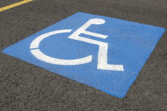Accessible parking space sign on asphalt.