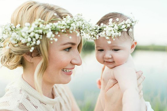 Mother and baby enjoying spring outdoors with floral crown.