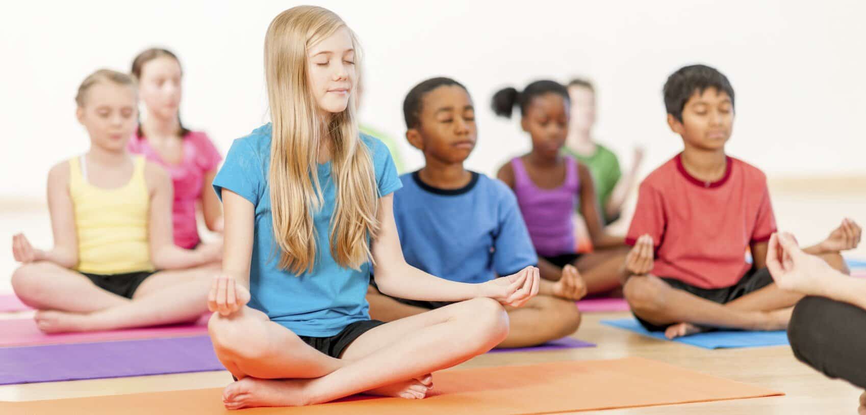 Children doing yoga to promote wellness and relaxation for kids' health.