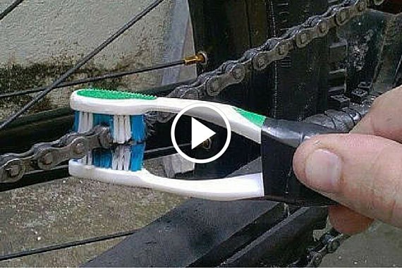 Bicycle chain cleaning using a toothbrush to remove dirt and grime.