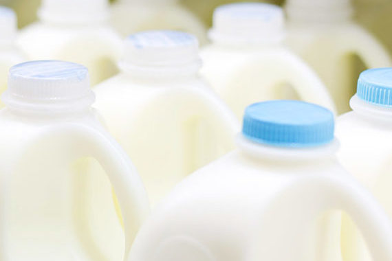 Dairy farmers protest with milk bottles after milk price drop.