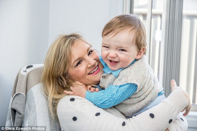 Happy mother holding her smiling young son indoors.