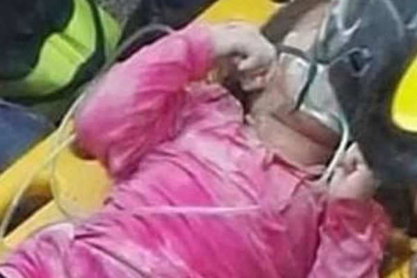 Young girl in pink rescue gear saving her sister after Italy earthquake.