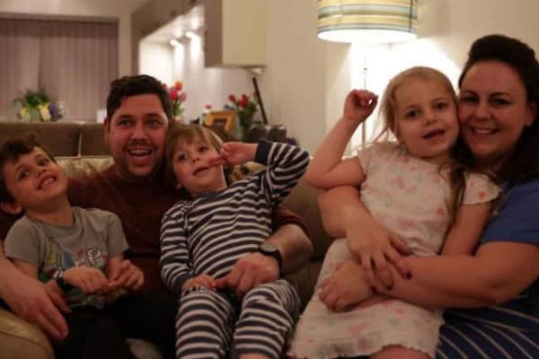 Happy family relaxing on sofa with children and parents.