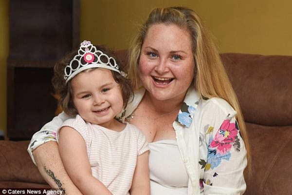 Happy mother and young girl wearing a tiara, smiling and embracing each other at home.