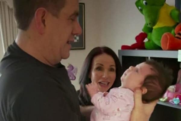 Happy family with parents and baby girl in a cozy home setting.