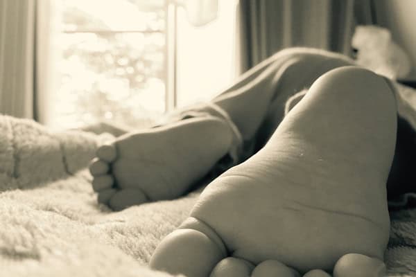 A child lying on a bed, symbolising a desire for normal life after off-grid disappearance.