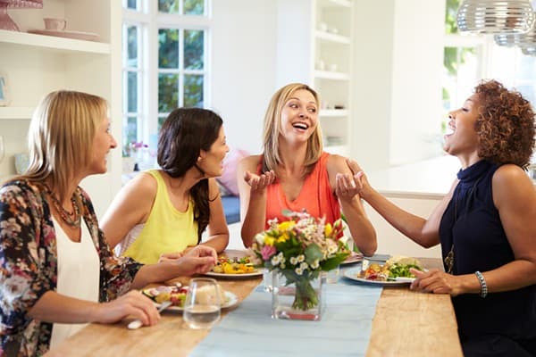 Mums enjoying a fun Christmas party without kids, sharing laughs and celebrating together.