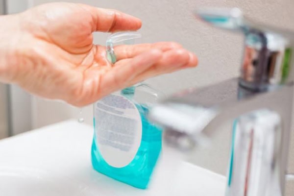 Antibacterial soap being dispensed from a pump bottle into a hand.