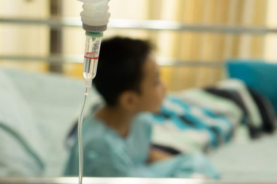 Child in hospital bed with IV drip, awaiting diagnosis.