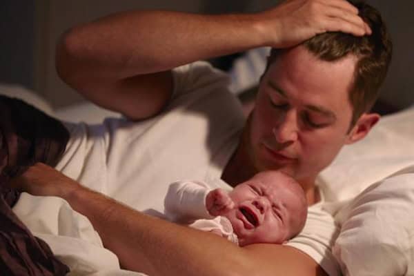 Father soothing distressed baby after a difficult incident.