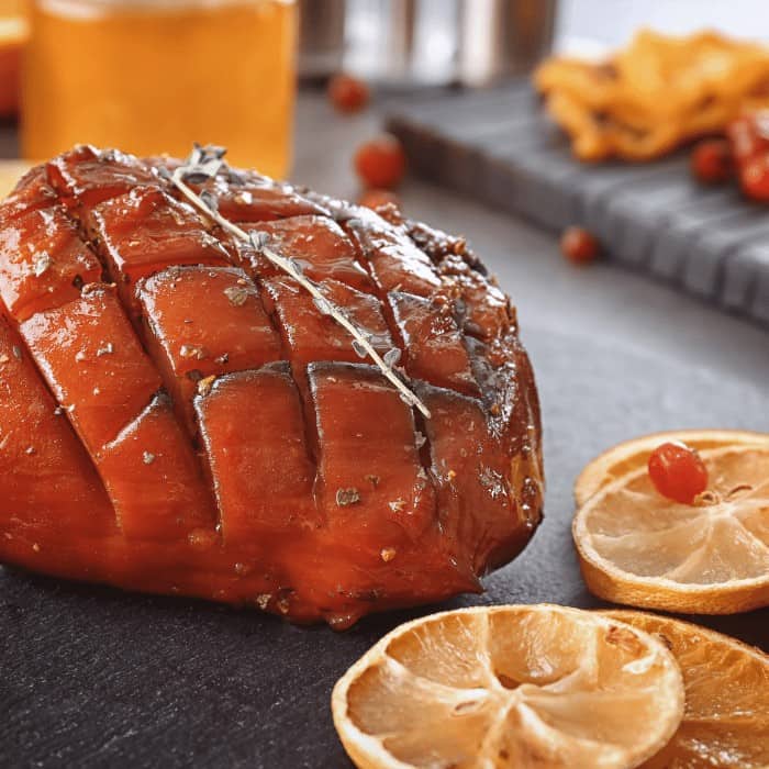 Orange glazed ham with citrus slices and a sweet glaze, perfect for holiday celebrations and family.