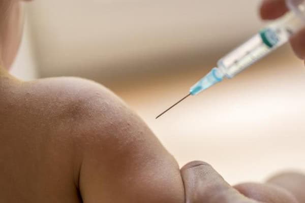 Baby receiving hepatitis B vaccine injection in healthcare setting.