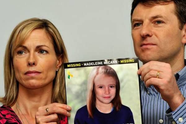Parents of Madeline McCann hold a photo amid controversy over her disappearance.