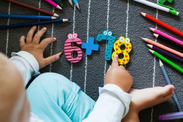 Baby learning numbers 6 and 7 with colourful educational toys.