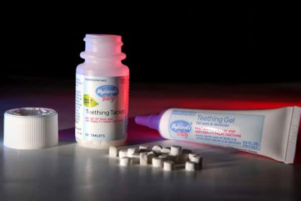 Teething gel and tablets for babies on pharmacy shelf.