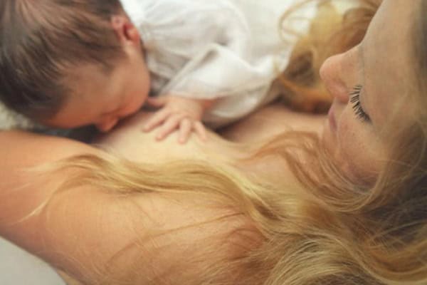 Mother breastfeeding her infant, showcasing maternal bonding and nurturing care.