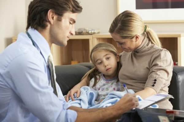 Family consultation with doctor and young girl at home.