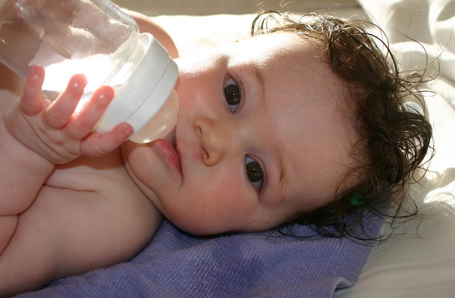 Baby drinking from a bottle, signs of dehydration in children and infants.