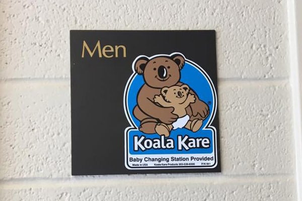 Men's bathroom sign with Koala Kare baby changing station.