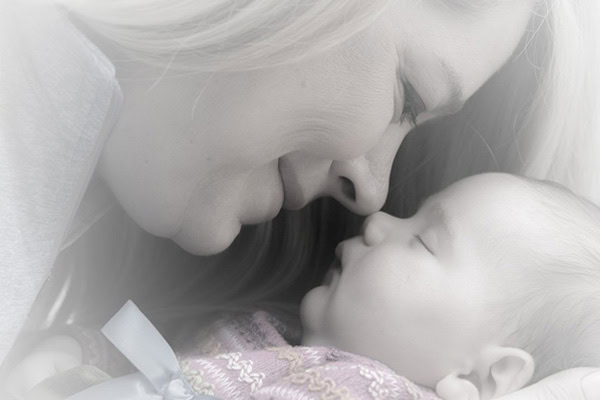 Mother singing lullaby to baby, promoting emotional development and bonding.