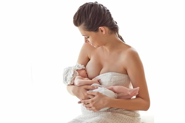 Mother breastfeeding her newborn baby in a tender moment.