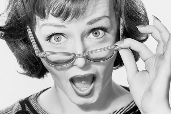 Surprised woman with glasses revealing secret confessions.