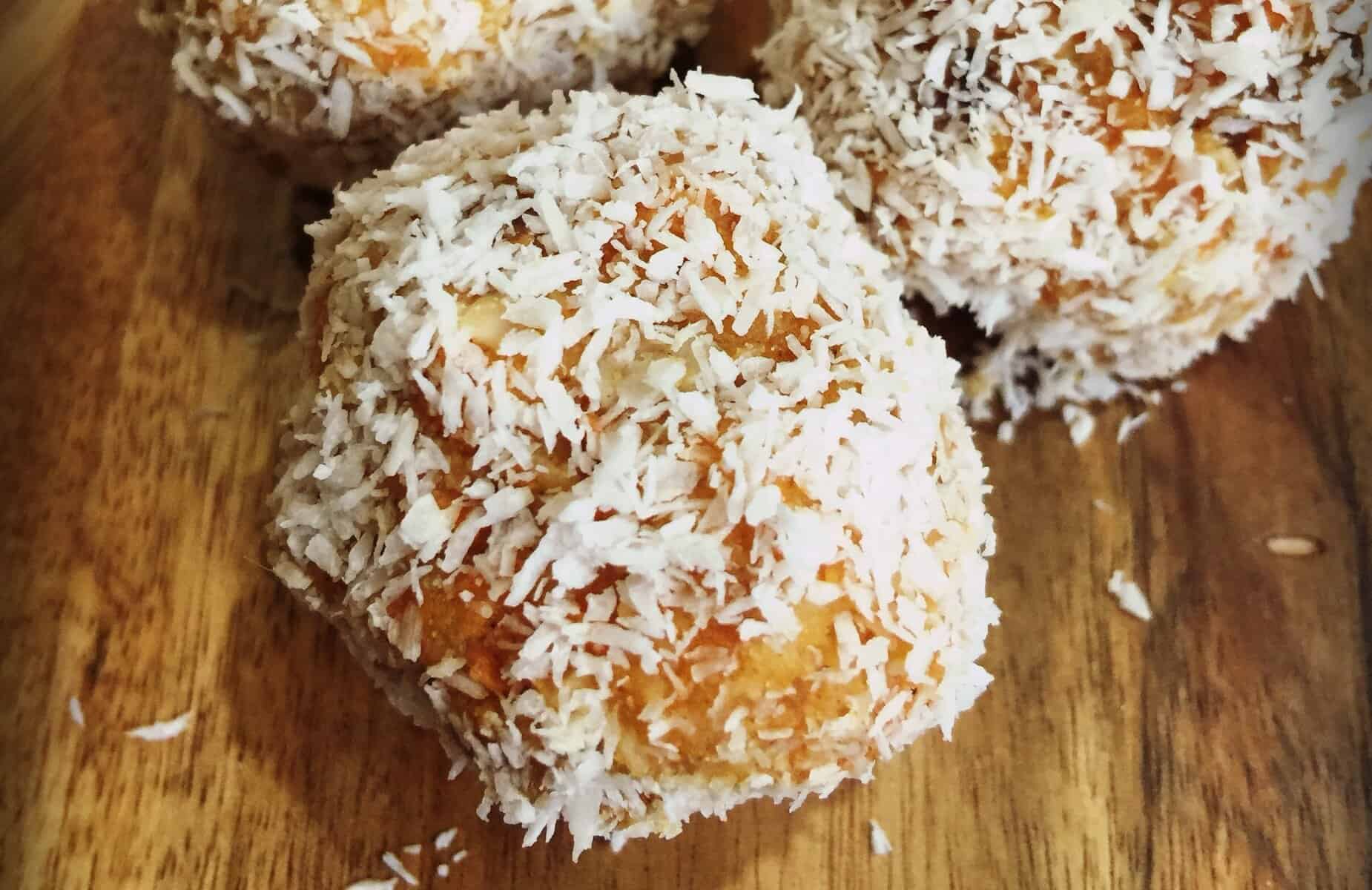 Delicious carrot cake bliss balls coated in shredded coconut, perfect for healthy snacks or dessert.