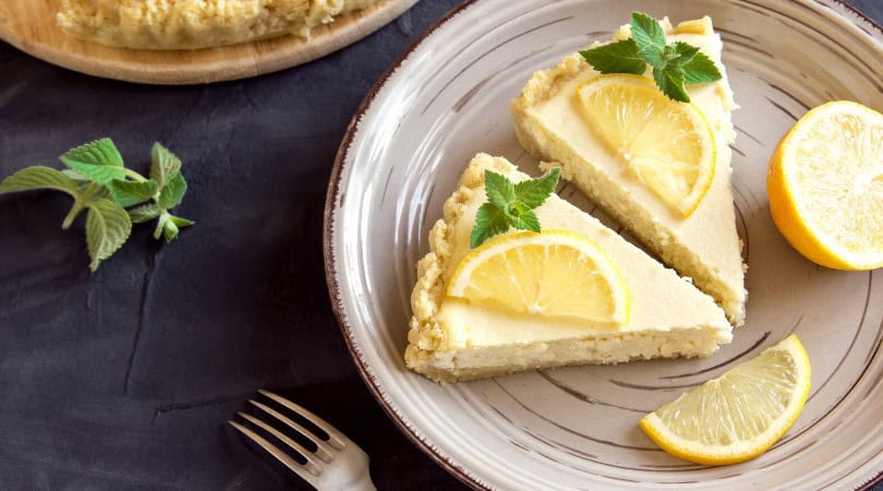 Delicious Piña Colada Cheesecake with lemon slices and mint garnish.