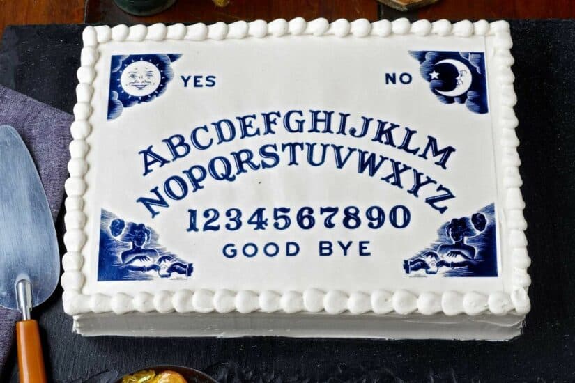 Spooky Ouija board cake with moon and sun symbols for Halloween celebrations.