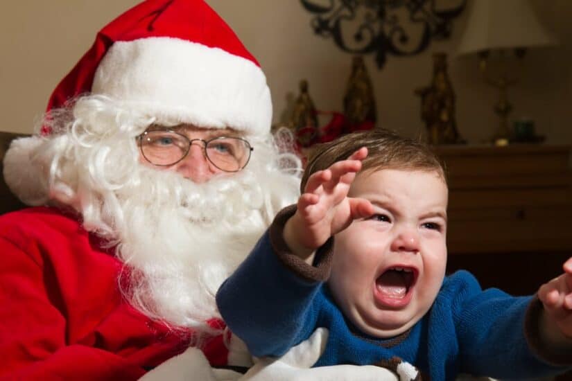Frustrated child crying during Santa photo with Santa Claus.