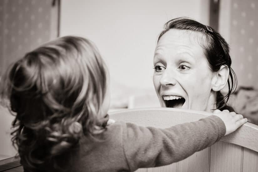 Child and mother playing peek-a-boo, promoting bonding and developmental skills.