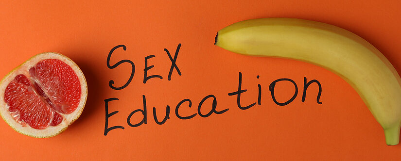 Child-friendly sex education books with fruits on orange background.
