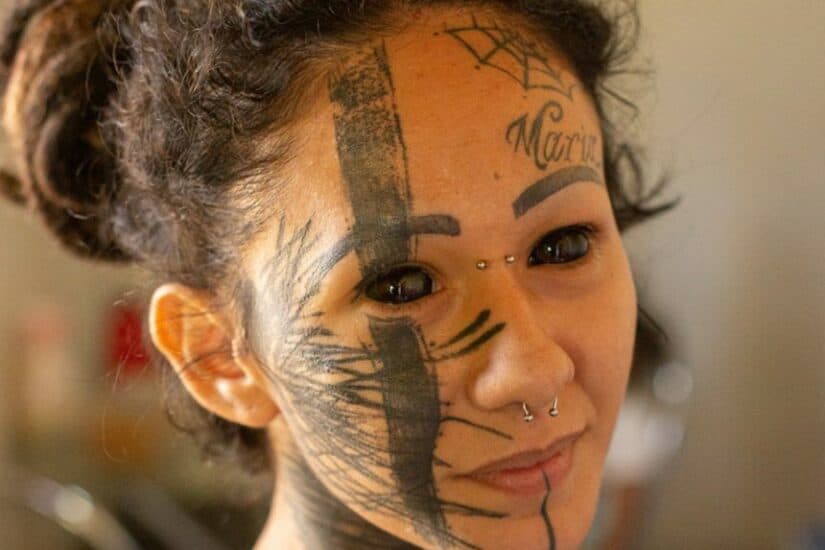 Eyeball tattooing procedure at an extreme tattoo studio, showcasing a person with eye and face tatto.