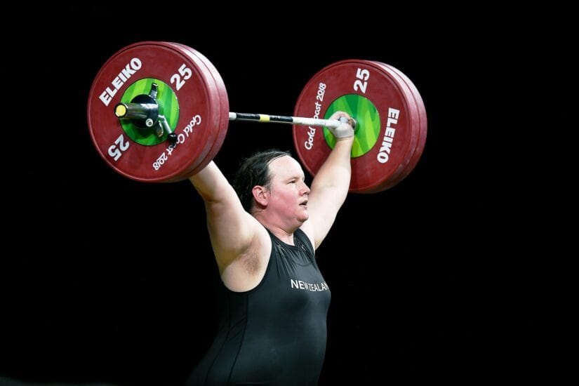 Weightlifting athlete lifting a barbell with red weights.